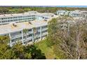 Aerial view of condo building with white railings and a lush green lawn at 1706 Belleair Forest Dr # 348, Belleair, FL 33756