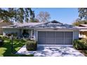 Charming single-story home featuring a spacious screened garage, lush lawn, and well-maintained landscaping at 10525 Mira Vista Dr, Port Richey, FL 34668