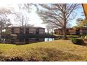 Scenic backyard featuring a serene pond and lush greenery, with a community building visible in the background at 2689 Sabal Springs Cir # 103, Clearwater, FL 33761