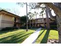 Two-story condo community showcasing lush landscaping, mature trees, and inviting walkways at 2689 Sabal Springs Cir # 103, Clearwater, FL 33761