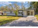 Inviting single-story home featuring a covered carport and fresh landscaping at 306 Midwood Dr, Plant City, FL 33566