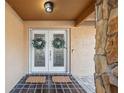 Inviting double front doors adorned with wreaths, set against a stone accent wall and decorative tile flooring at 3092 Osprey Ln, Clearwater, FL 33762