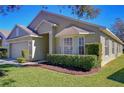 A single-story home featuring manicured landscaping, green grass, and large windows at 3133 Beaver Pond Trl, Valrico, FL 33596