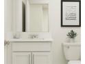 Modern bathroom featuring white cabinets, quartz countertop and framed mirror at 32045 Spiceberry St, San Antonio, FL 33576