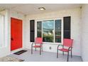 Charming front porch with a vibrant red door, black shutters, and comfortable seating at 334 Club Manor Dr, Sun City Center, FL 33573