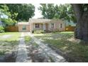 Quaint single-story home with light-colored stucco, white trim, and a concrete driveway in a lush setting at 3612 W Tampa Cir, Tampa, FL 33629