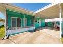 Side angle of turquoise house, screened in porch and covered carport with view of washer and dryer at 3774 Arkansas Ne Ave, St Petersburg, FL 33703