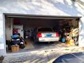 Spacious garage featuring a car, lawnmower, and ample storage space at 39349 & 39343 Rusbe Dr, Zephyrhills, FL 33540