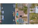 Aerial view of a home with a backyard pool, private dock, and lush landscaping on a waterfront property at 4195 Des Prez Ct, Hernando Beach, FL 34607