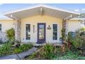 Inviting front porch showcasing stone accents, a decorative door, and manicured landscaping at 4408 W Lackland Pl, Tampa, FL 33616