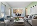 Bright living room with stylish furniture, including a sofa and armchairs, and hardwood floors at 4408 W Lackland Pl, Tampa, FL 33616
