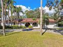 Charming single story home with an arched entrance and a well maintained front yard surrounded by mature trees at 4609 W San Miguel St, Tampa, FL 33629