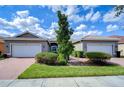 Beautiful home featuring a well-manicured lawn and symmetrical landscaping enhancing curb appeal at 4868 Marble Springs Cir, Wimauma, FL 33598