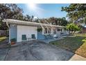 Charming single-story home featuring a metal roof, front porch seating, and an attached one-car garage at 5410 Tangerine Dr, Zephyrhills, FL 33542