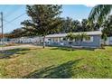 Well maintained home with a metal roof, manicured lawn, and mature landscaping at 5410 Tangerine Dr, Zephyrhills, FL 33542