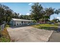 Exterior shot of a well-maintained home with a metal roof, and driveway with room for extra parking at 5410 Tangerine Dr, Zephyrhills, FL 33542