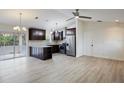Open concept kitchen with stainless steel appliances, dark cabinets, light countertops and wood floors at 6160 Van Dine St, Englewood, FL 34224