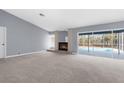 Open living room with a brick fireplace and sliding glass doors to the pool area at 8701 Braxton Dr, Hudson, FL 34667