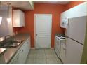 Efficient kitchen with white cabinets, stainless steel sink, and tile flooring at 9404 Crescent Loop Cir # 104, Tampa, FL 33619