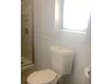 Clean bathroom features toilet, shower, and a window for natural light at 9620 Pieces Of Eight Trl, Placida, FL 33946