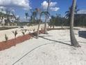 Exterior features freshly landscaped yard with palm trees and beach access at 9620 Pieces Of Eight Trl, Placida, FL 33946