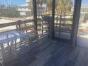 View of a screened porch with table, chair, and barbecue overlooking the beach at 9620 Pieces Of Eight Trl, Placida, FL 33946