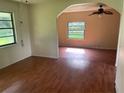 An open living room featuring wood-look floors and multiple windows for natural light at 9707 Lithia Pinecrest Rd, Lithia, FL 33547