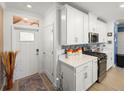 Bright kitchen with white cabinets, stainless steel appliances, and a mosaic backsplash at 17308 Holly Well Ave, Wimauma, FL 33598