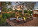 Lush backyard oasis with a tranquil pond, wooden bridge, and ambient lighting at 1166 Granada St, Clearwater, FL 33755