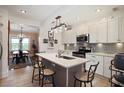 Modern kitchen featuring white cabinets, stainless steel appliances, and a central island with bar seating at 1166 Granada St, Clearwater, FL 33755