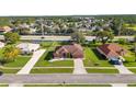 Aerial view of a neighborhood street featuring a cozy single-story home with manicured lawn and landscaping at 13481 Pullman Dr, Spring Hill, FL 34609