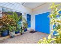 Inviting entrance with potted plants, tiled floor, and a vibrant blue front door at 1411 Water View W Dr, Largo, FL 33771