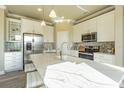 Bright kitchen with stainless steel appliances, white cabinets and an island with quartz countertops at 14466 Pioneer Ridge Dr, Hudson, FL 34667