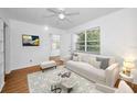 Bright living room featuring hardwood floors, a ceiling fan, and a cozy seating area at 1611 Canterbury N Rd, St Petersburg, FL 33710