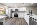 Bright kitchen with stainless steel appliances, white cabinets, and mosaic backsplash at 19029 Us Highway 19 N # 19C, Clearwater, FL 33764