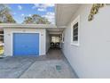 Inviting covered entryway leading to a blue garage door and featuring a cozy seating area at 214 Driftwood N Dr, Palm Harbor, FL 34683