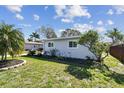 This is a sunny yard with landscaped garden beds adding to the property's curb appeal at 214 Driftwood N Dr, Palm Harbor, FL 34683