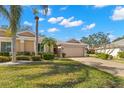 Inviting single-story home with lush landscaping and paver driveway leading to an attached two-car garage at 2218 Mayfield Palms Ln # 323, Sun City Center, FL 33573