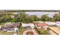 An aerial view showcasing the property's location near a serene lake surrounded by lush greenery and neighboring homes at 2405 Indigo Dr, Clearwater, FL 33763