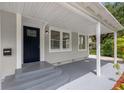 Inviting covered front porch with a dark-colored door and a view of the well-kept yard at 2835 Valencia S Way, St Petersburg, FL 33705
