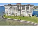 An aerial view of a condo building, with a large manicured lawn, and waterfront access at 4775 Cove Cir # 205, St Petersburg, FL 33708