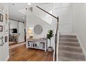 Bright foyer with staircase, hardwood floors, and stylish decor, enhanced by modern wall paneling at 6219 Voyagers Pl, Apollo Beach, FL 33572