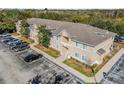 Aerial view of condo building, showcasing the parking lot, landscaping and nearby wooded area at 6414 Hollydale Pl # 101, Riverview, FL 33578