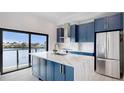 Modern kitchen featuring blue cabinets, stainless appliances, marble countertops and a water view at 774 Gran Kaymen Way, Apollo Beach, FL 33572
