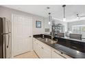 Well-lit kitchen featuring stainless steel appliances, granite countertops, and a breakfast bar overlooking the living area at 800 S Dakota Ave # 323, Tampa, FL 33606