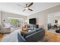Inviting living room with large windows, ceiling fan, modern decor, and an open doorway to the bedroom at 800 S Dakota Ave # 323, Tampa, FL 33606