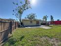 View of the home's back exterior highlighting the expansive yard, privacy fence, and covered pool at 808 20Th W Ave, Bradenton, FL 34205
