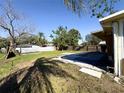 Spacious backyard featuring a covered pool area, mature trees, and a privacy fence at 808 20Th W Ave, Bradenton, FL 34205
