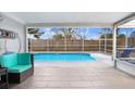 Relaxing screened-in pool area with comfortable seating, ideal for entertaining or enjoying a quiet afternoon at 9040 Lunar Ln, Port Richey, FL 34668