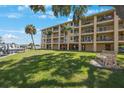 Exterior view of the building with green lawn, boat docks, and ample balconies at 1125 Pinellas Bayway S # 305, St Petersburg, FL 33715